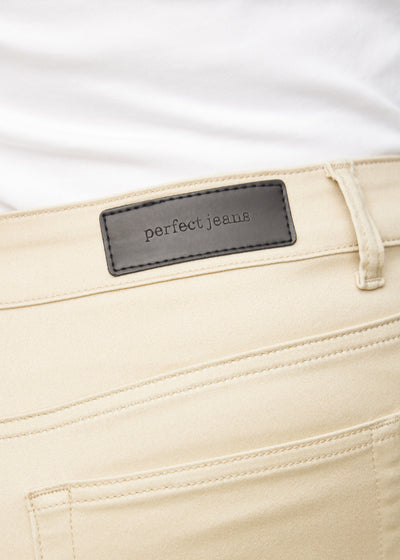 Baglommen på et par beige slim jeans, hvor man kan se logoet på en plus-size model.