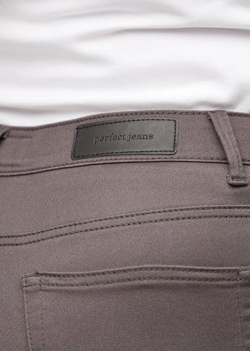 Baglommen på et par gråbrune slim jeans, hvor man kan se logoet på en plus-size model.