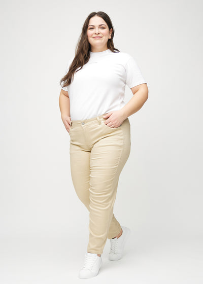 Plus-size model går ind i billedet, strækker i jeansene, viser dem frem ved at dreje rundt, og forlader derefter billedet.